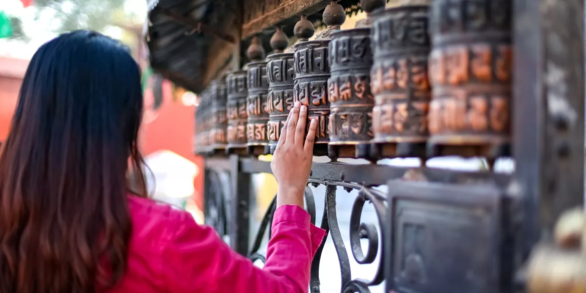 Girl Passing By Buddhist Prayer Wheel