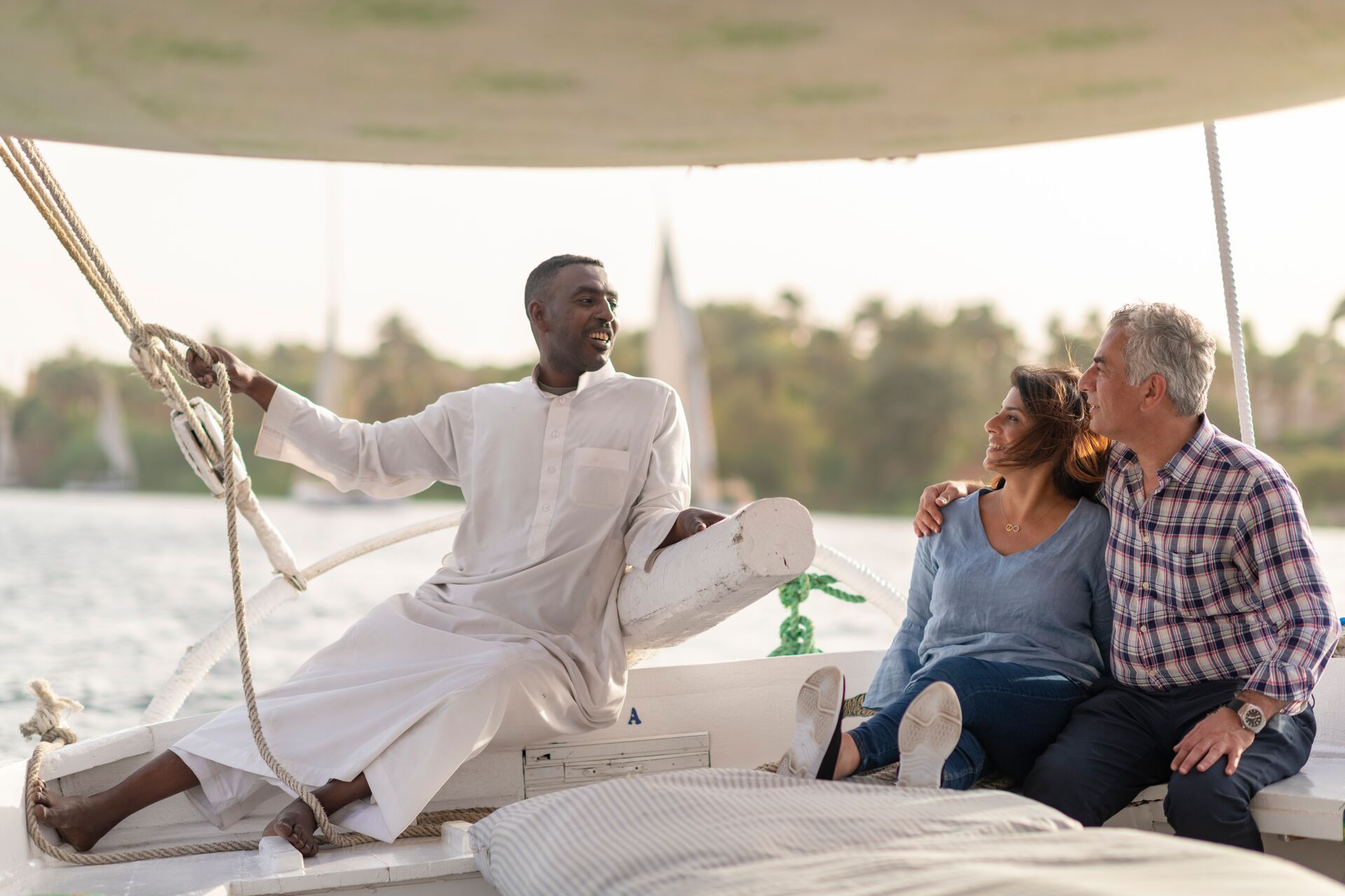 Guests chatting to a Felucca operator while sailing down the River Nile in Egypt 