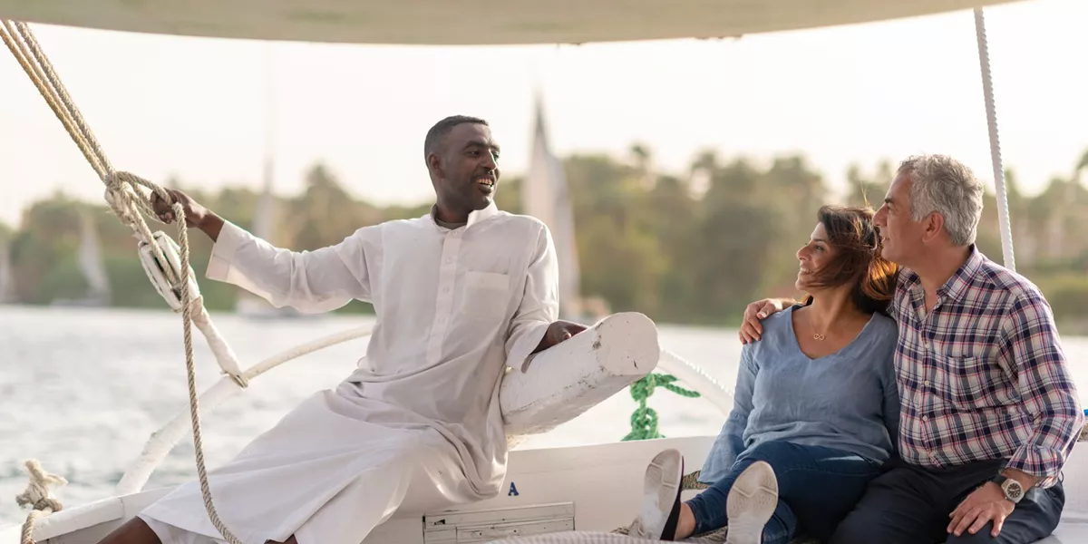 Guests chatting to a Felucca operator while sailing down the River Nile in Egypt