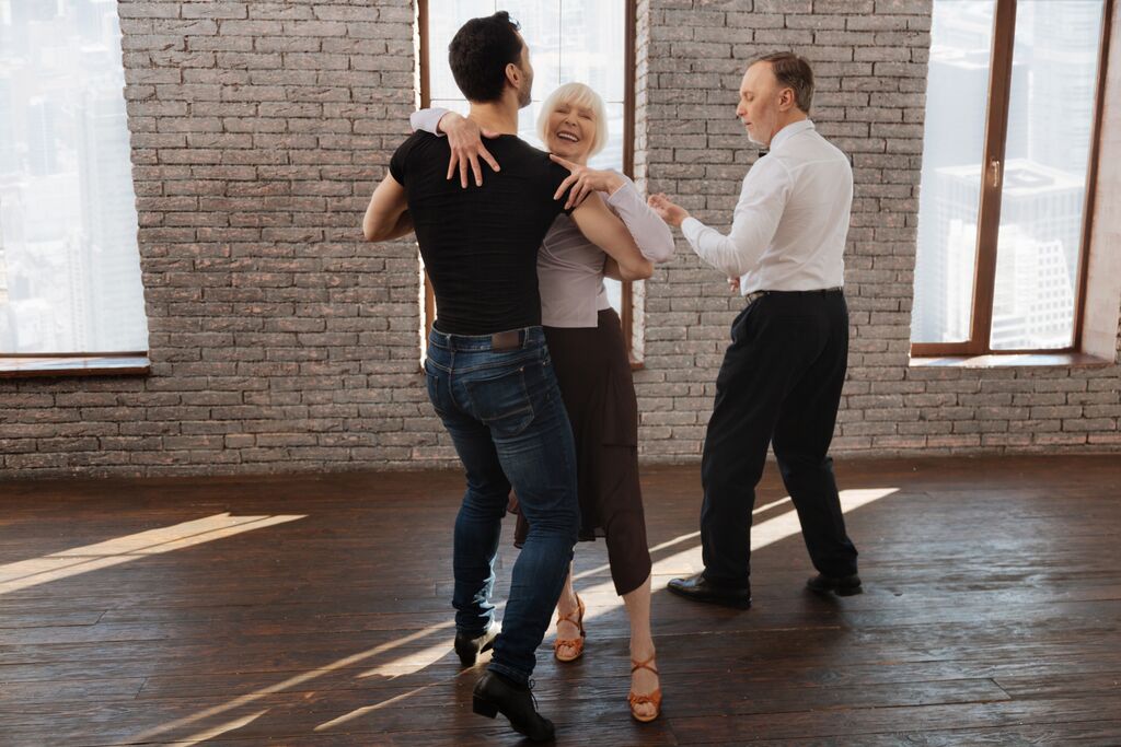 Dance Instructor Teaching a Couple to Waltz In The Ballroom