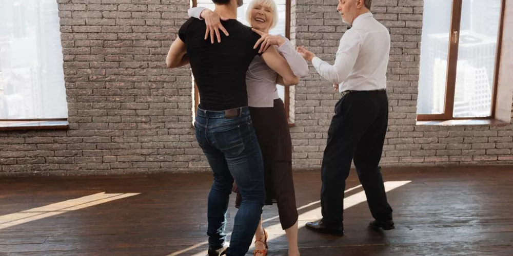 Dance Instructor Teaching a Couple to Waltz In The Ballroom