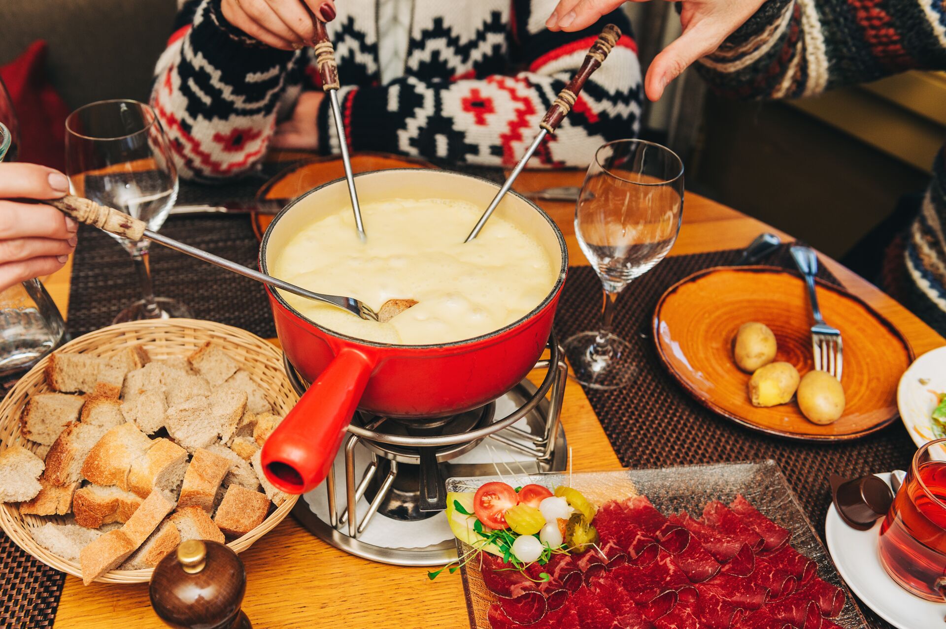 Friends Eating Cheese Fondue In A Cozy Traditional Swiss Restaurant