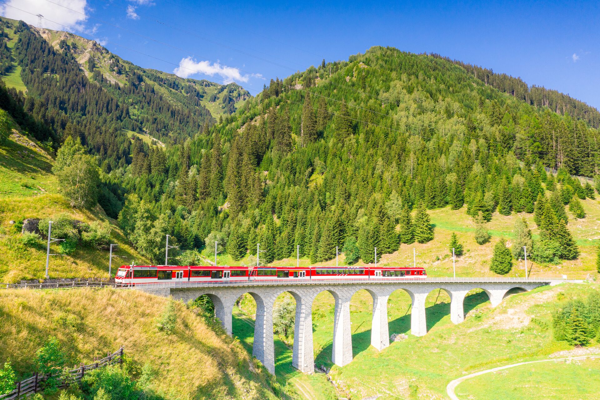 Glacier Express Train on the Tujetsch Viaduct on a sunny day in Switzerland