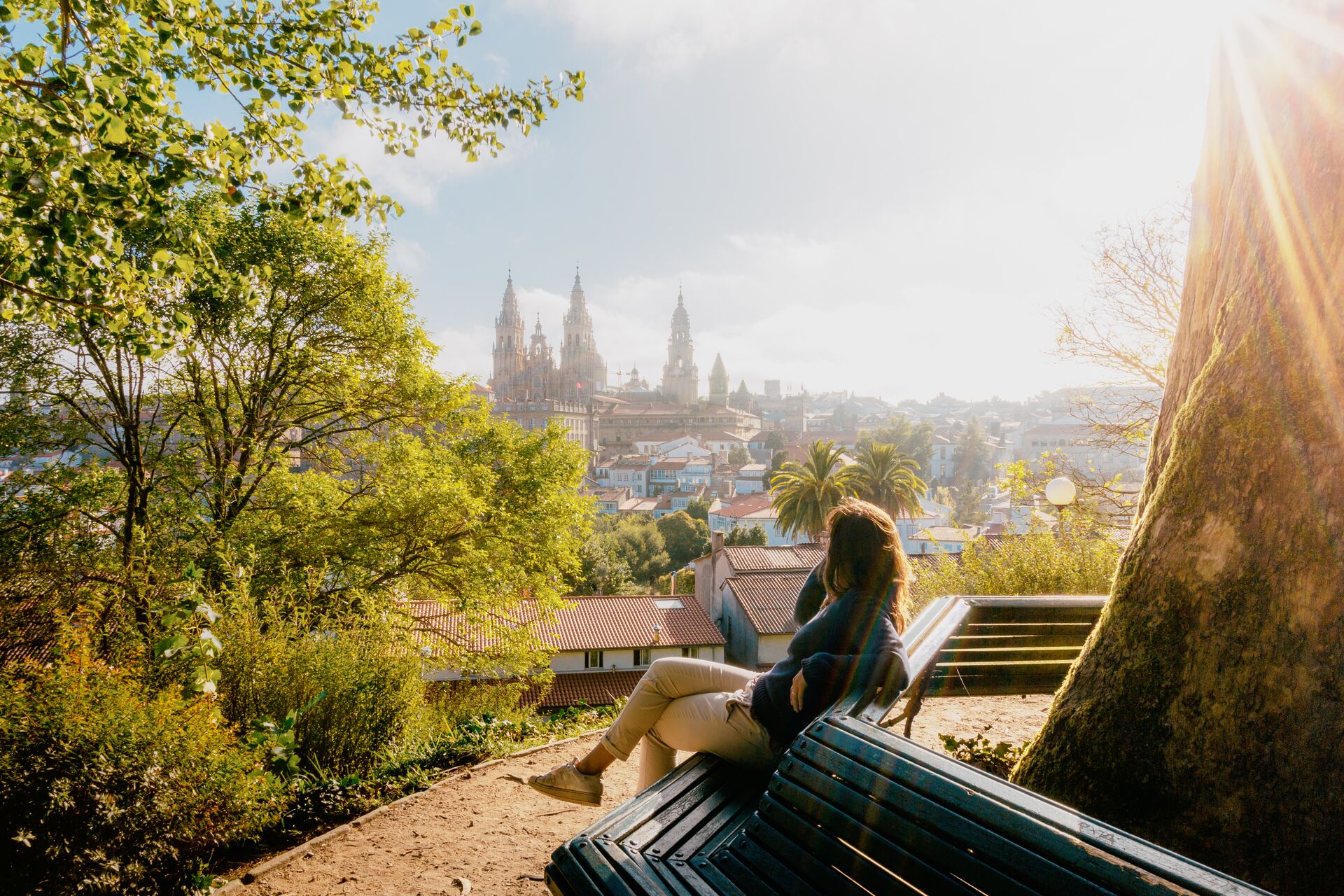 Woman watching the sun rise over Santiago de Compostela in Galicia, Spain