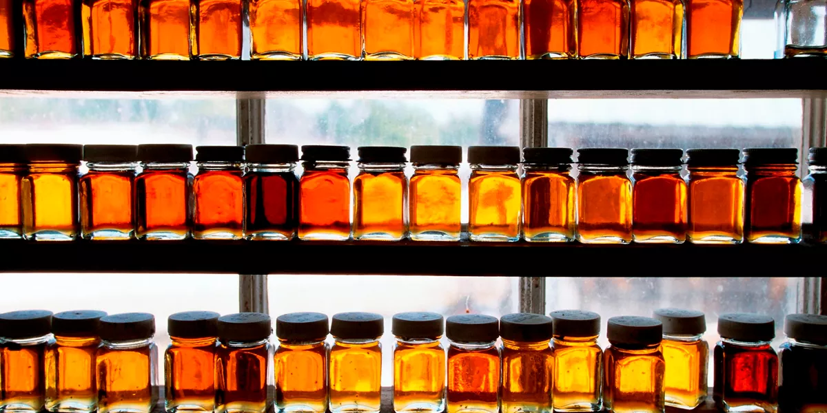 Maple syrup on on shelves with the sun behind them at Morse Farm Maple Sugarworks in Montpelier, USA