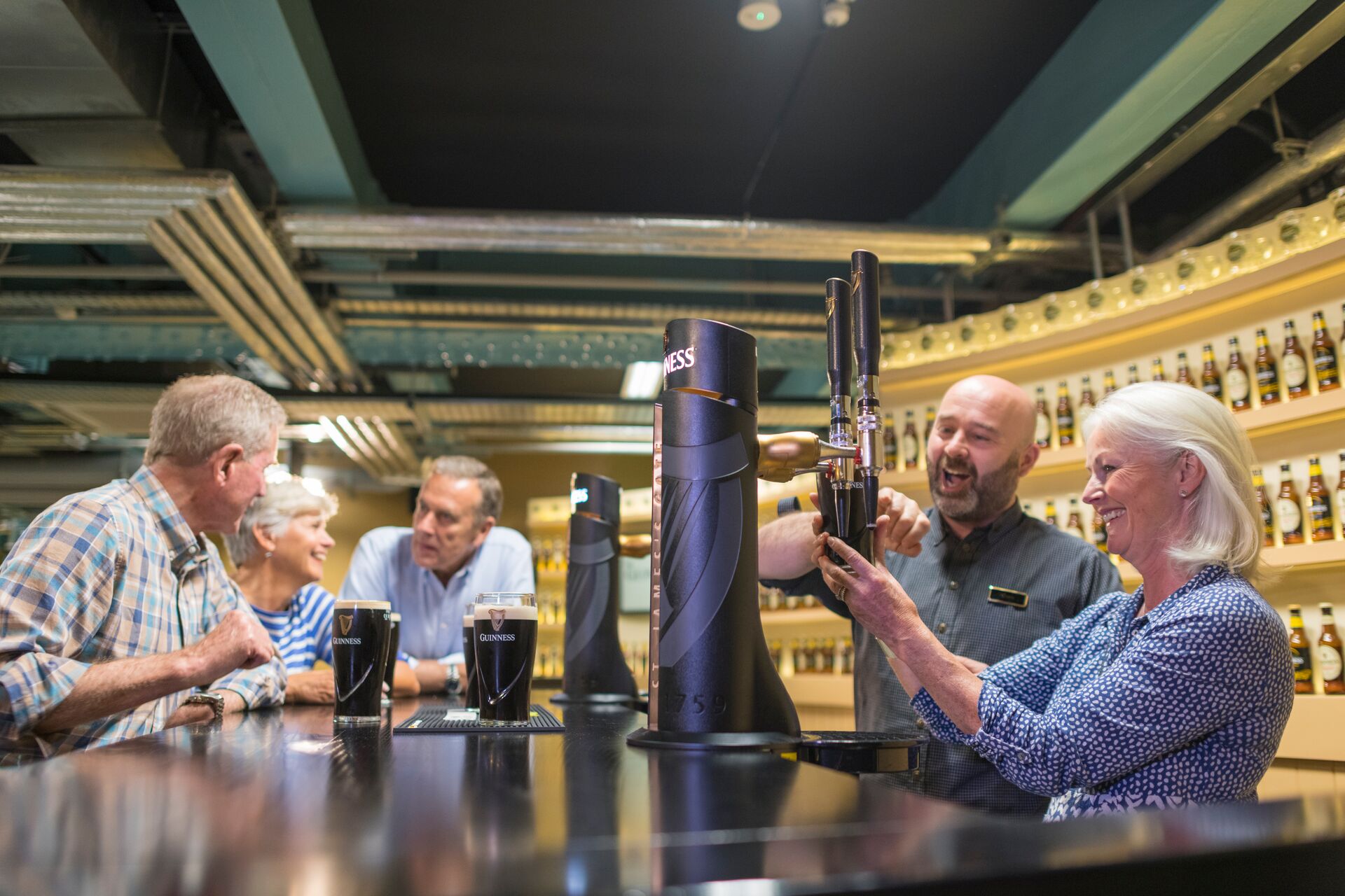 Guests pouring a pint of Guinness at the Guinness Factory Bar in Dublin, Ireland 