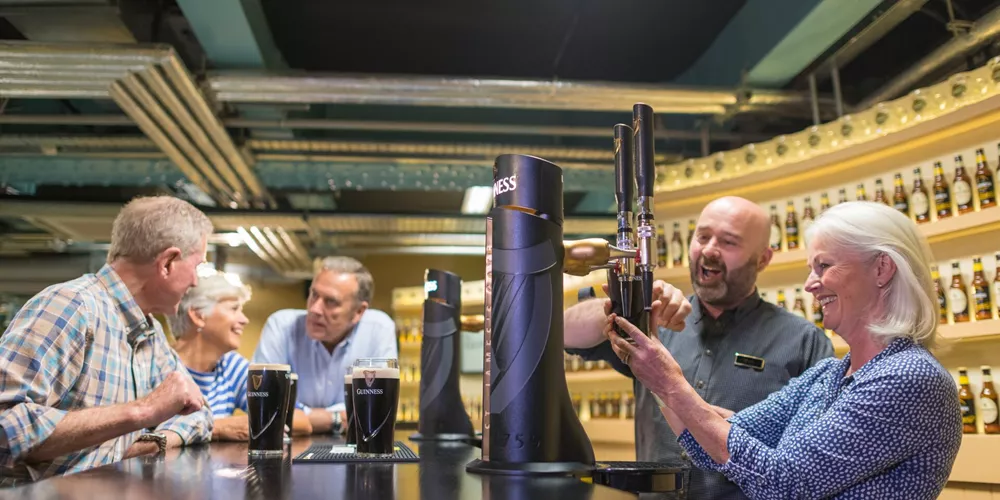 Guests pouring a pint of Guinness at the Guinness Factory Bar in Dublin, Ireland