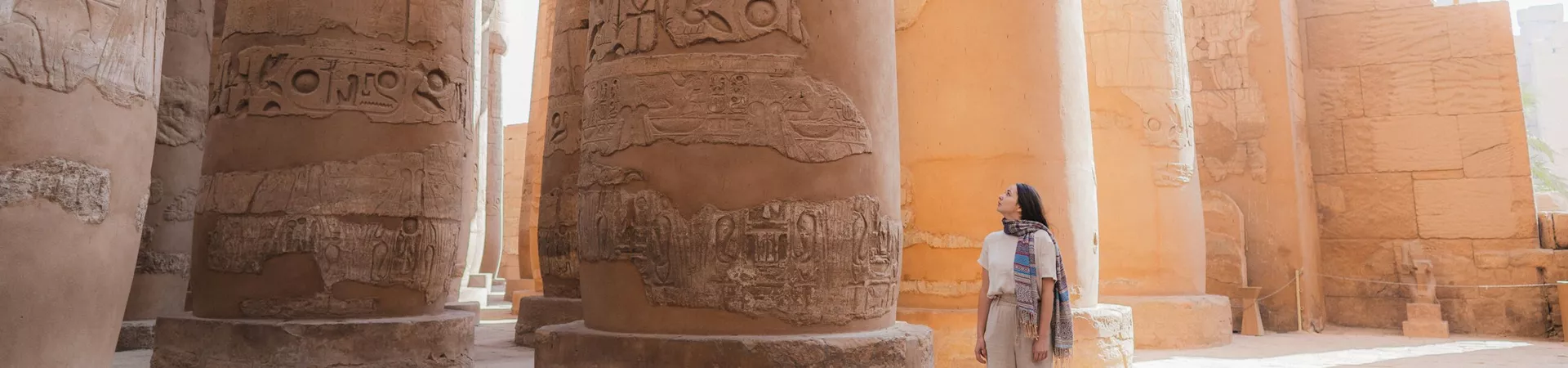 Woman admiring the hieroglyphics on the wall of an Egyptian temple