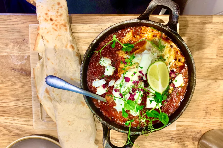 Traditional Arabic Breakfast Dish In Cast Iron Pan With Unleavened Wrap On Wooden Board 1215590616