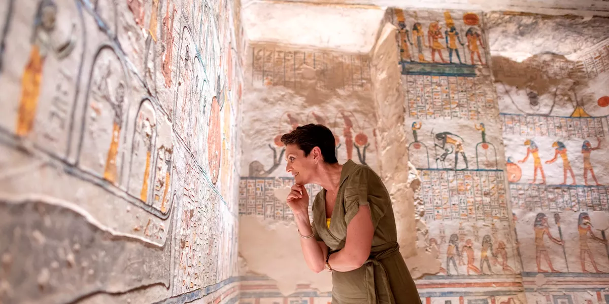Lady looking at decorated Egyptian wall