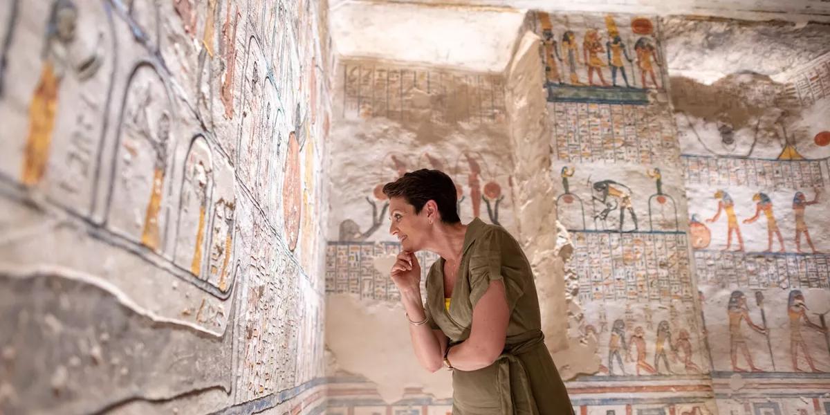 Woman looking at the hieroglyphics in Rameses VI Tomb in Luxor, Egypt