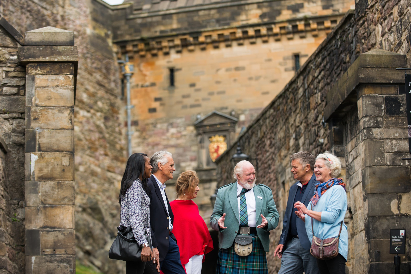 Group of tourists talking to a local expert at Edinburgh Castle in Edinburgh, Scotland