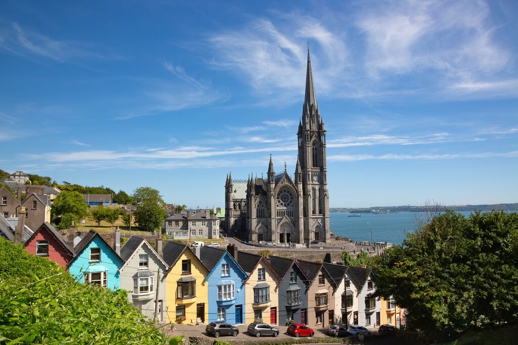 Ireland, County Cork, Cobh, Colorful Row Houses Standing Along Steep Street With Saint Colmans Cathedral In Background 1436192145