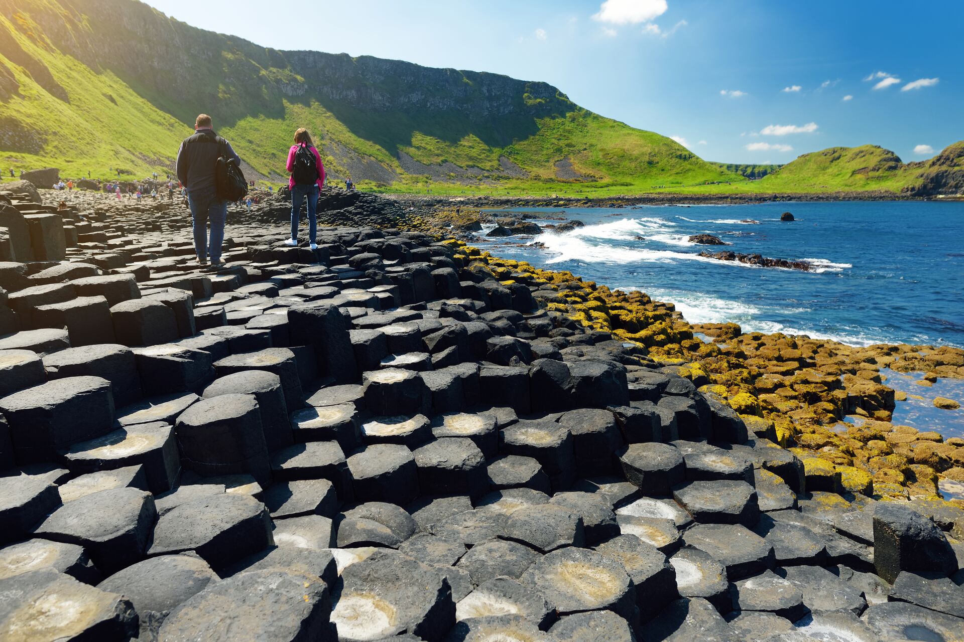 Large Two Tourists Walking At Giants Causeway, An Area Of Hexagonal Basalt Stones, County Antrim, Northern Ireland Famous Tourist Attraction, UNESCO World H 1174538488