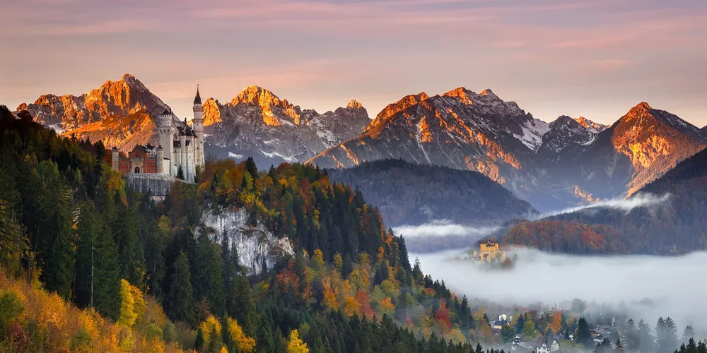 Neuschwanstein Castle in Bavaria, Germany surrounded by Autumn foliage