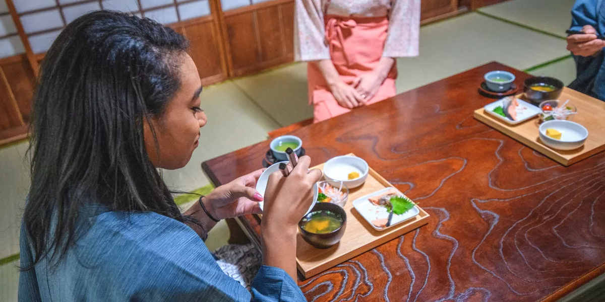 Woman trying traditional food at a Tokyo Ryokan