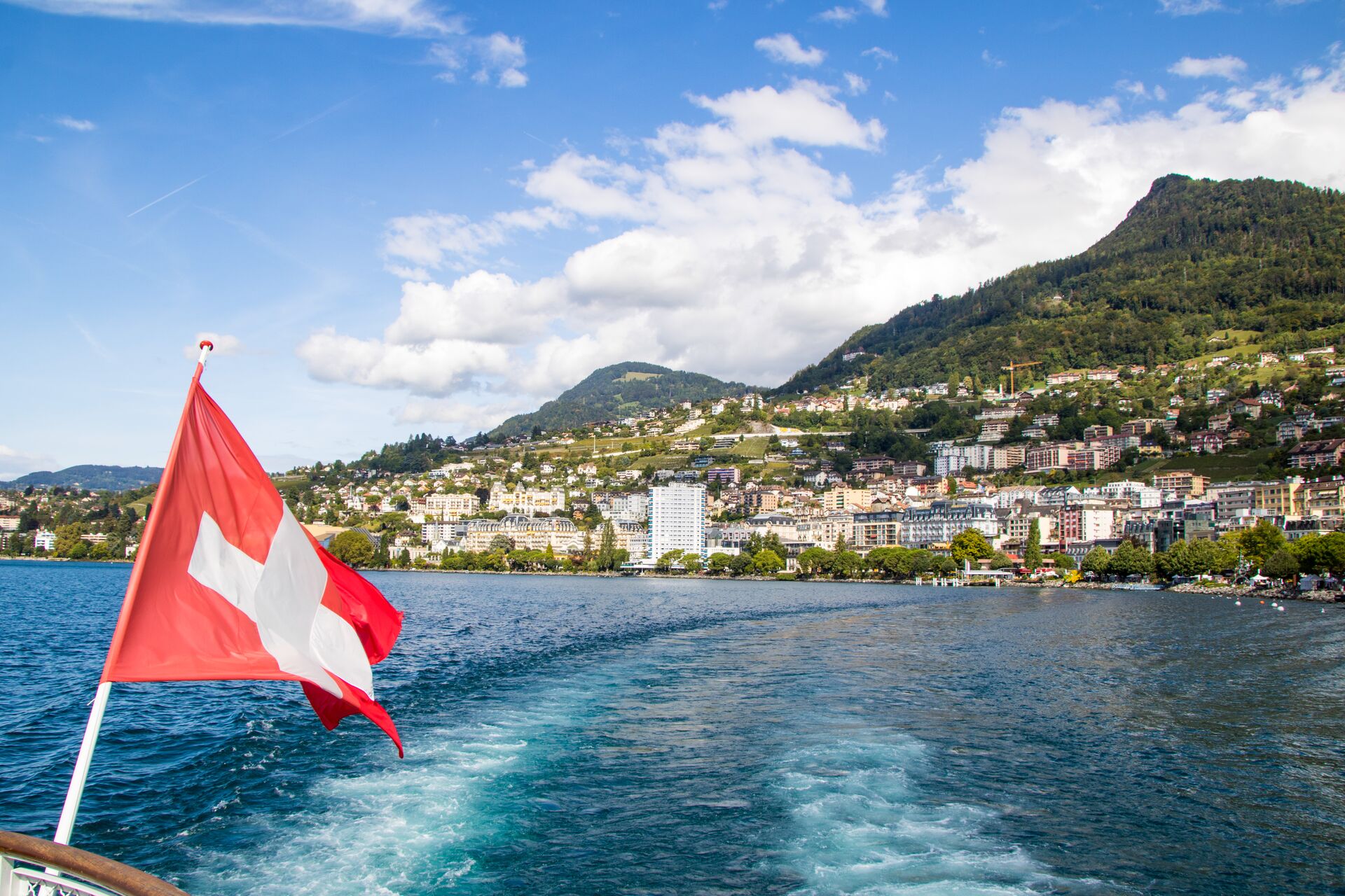Swiss flag in the foreground with Geneva in a the background