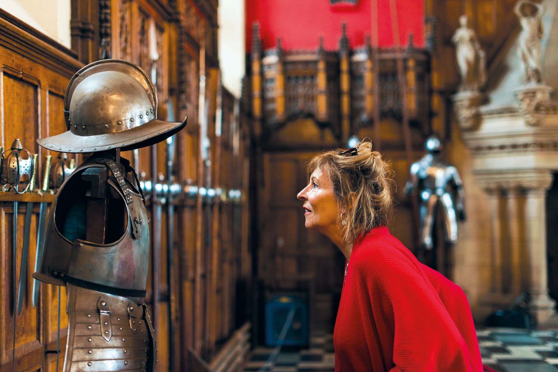 Woman looking at a suit of armour in Edinburgh Castle in Edinburgh, Scotland, UK