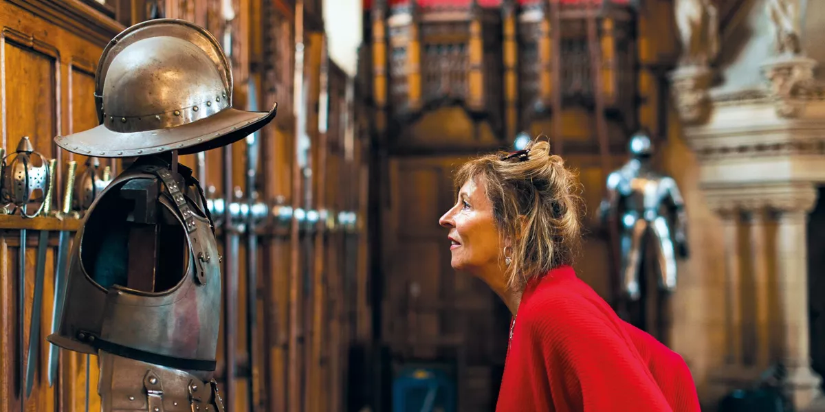 Woman looking at a suit of armour in Edinburgh Castle in Edinburgh, Scotland, UK