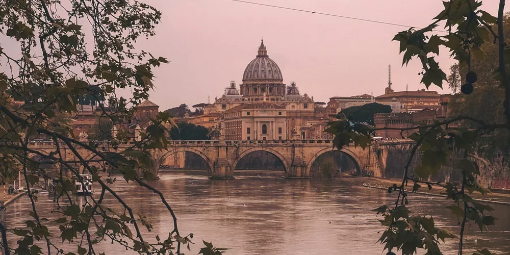 Vatican City in Rome, Italy as seen from across the Tiber River at dusk