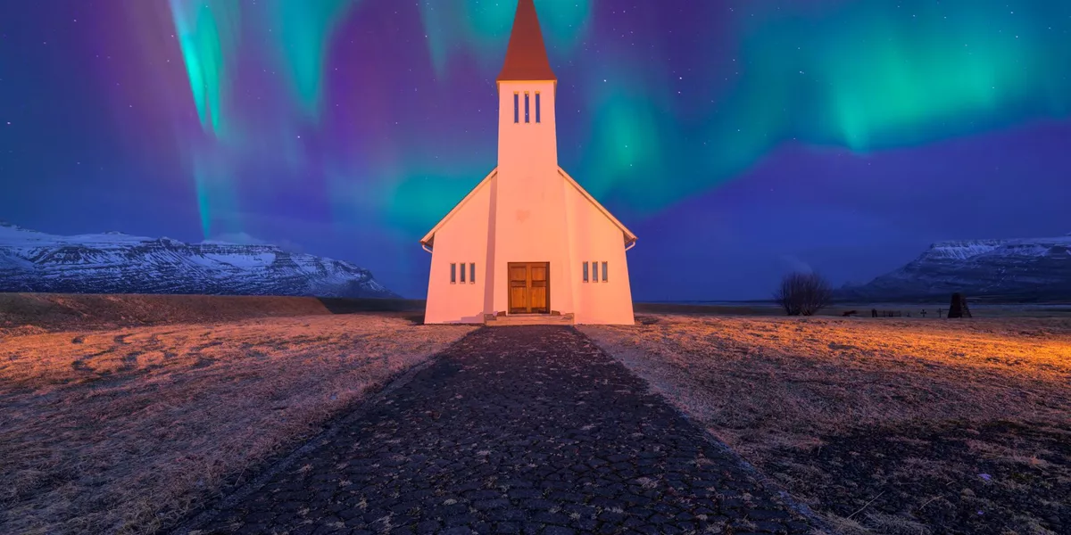 Northern Lights appearing over a Nordic church in Iceland