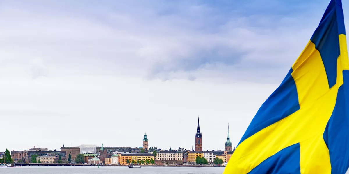 Urban Skyline Of The City Of Stockholm With The Swedish Flag On Foreground