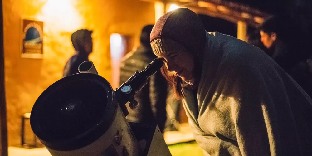 Woman using telescope at the Cusco Planetarium in Peru, South America