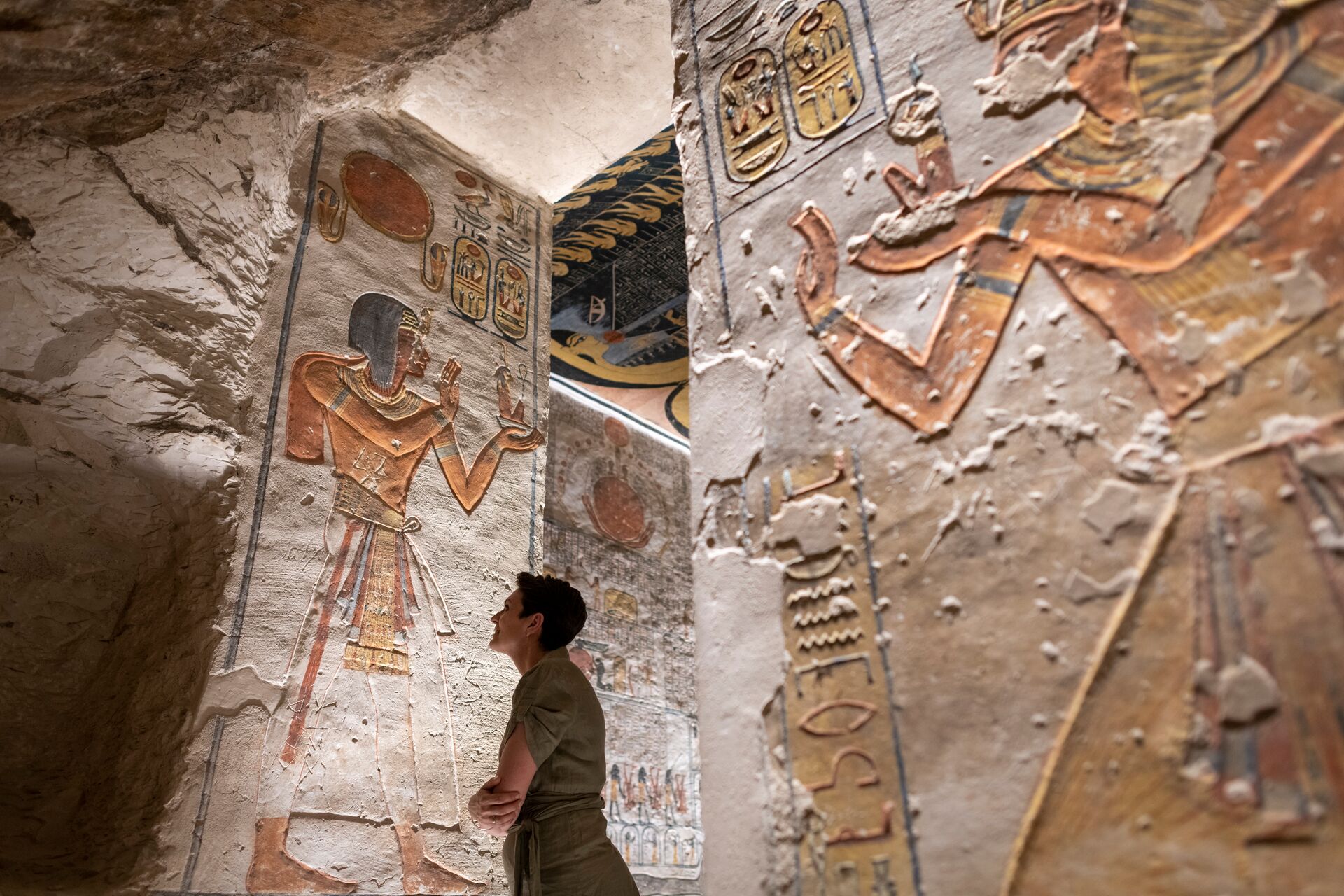 Woman looking at the hieroglyphics in Rameses VI Tomb in Luxor, Egypt 