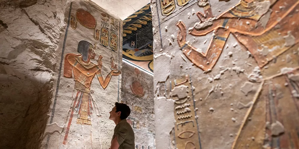 Woman looking at the hieroglyphics in Rameses VI Tomb in Luxor, Egypt