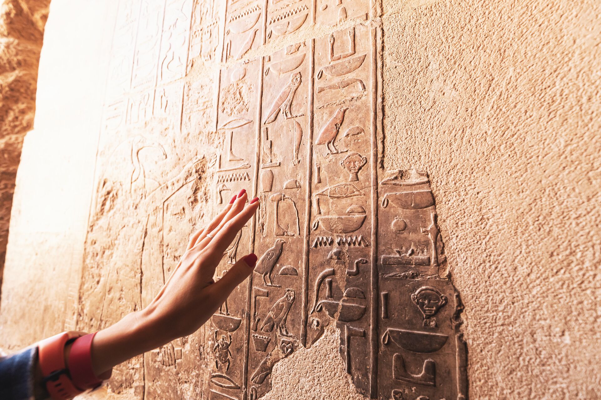 An Egyptologist or archaeologist reads and translates Egyptian hieroglyphs carved in stone