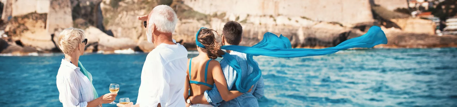 Couple on a sailing cruise looking at the coastline in the Mediterranean