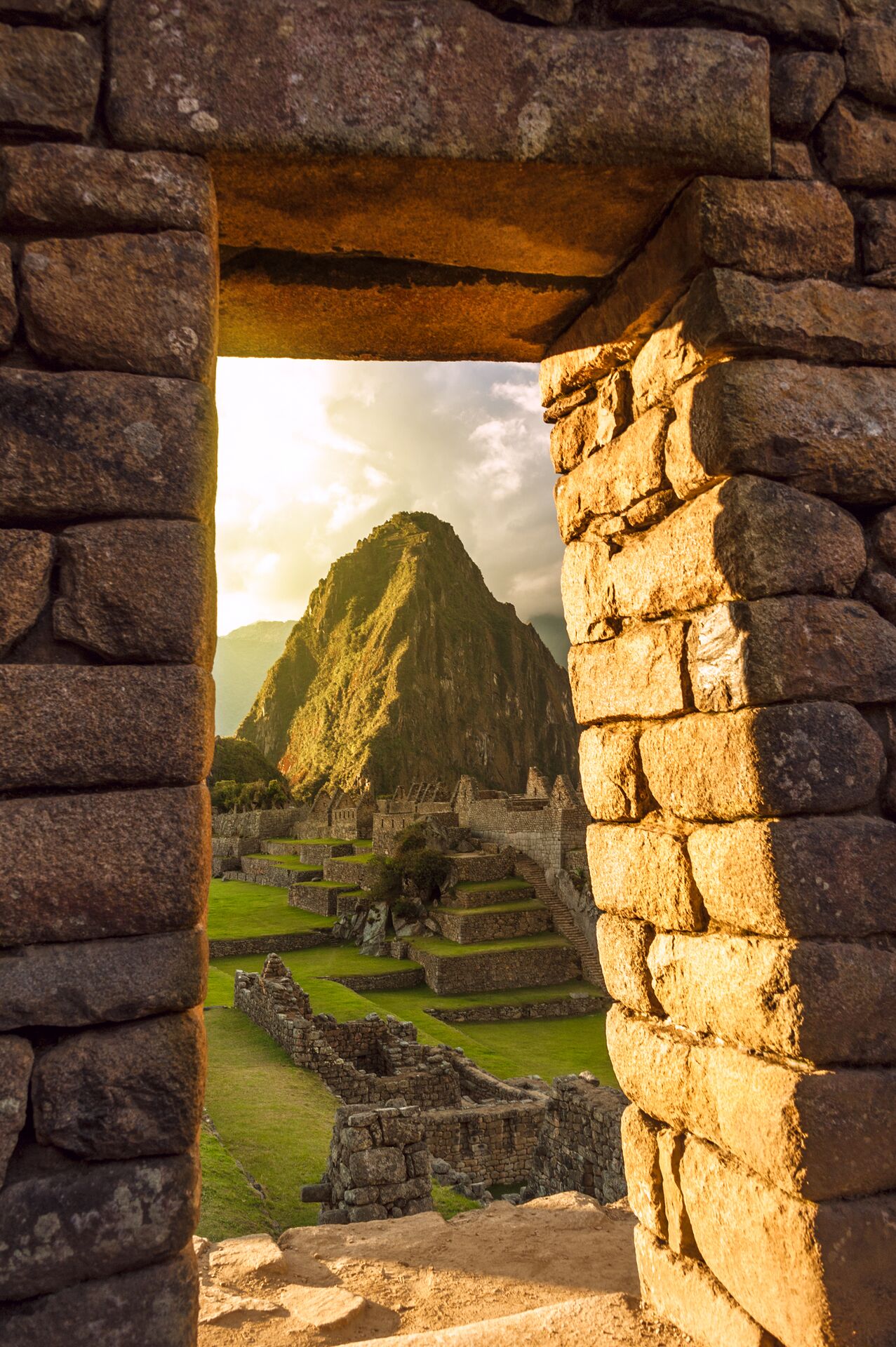 Machu Picchu, Peru peaking through an old stone archway