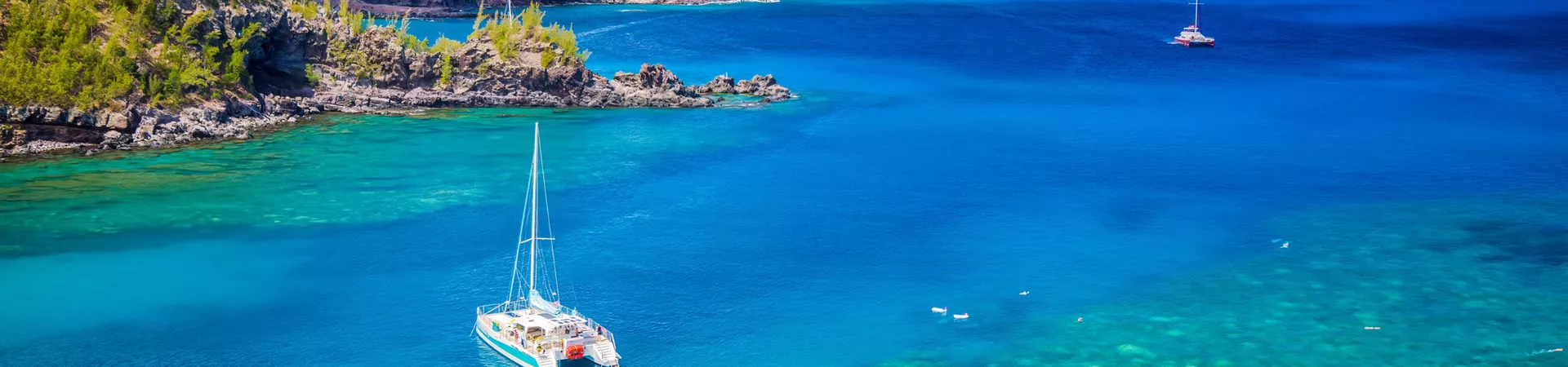 Catamaran floating in Honolua Bay in Maui, Hawaii