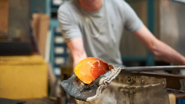 Large Glassblower In Workshop Forming Molten Glass On Blowpipe 683737691