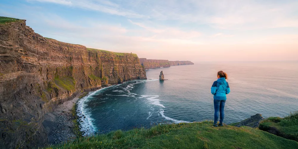 Woman gazing at the Cliffs of Moher in Ireland