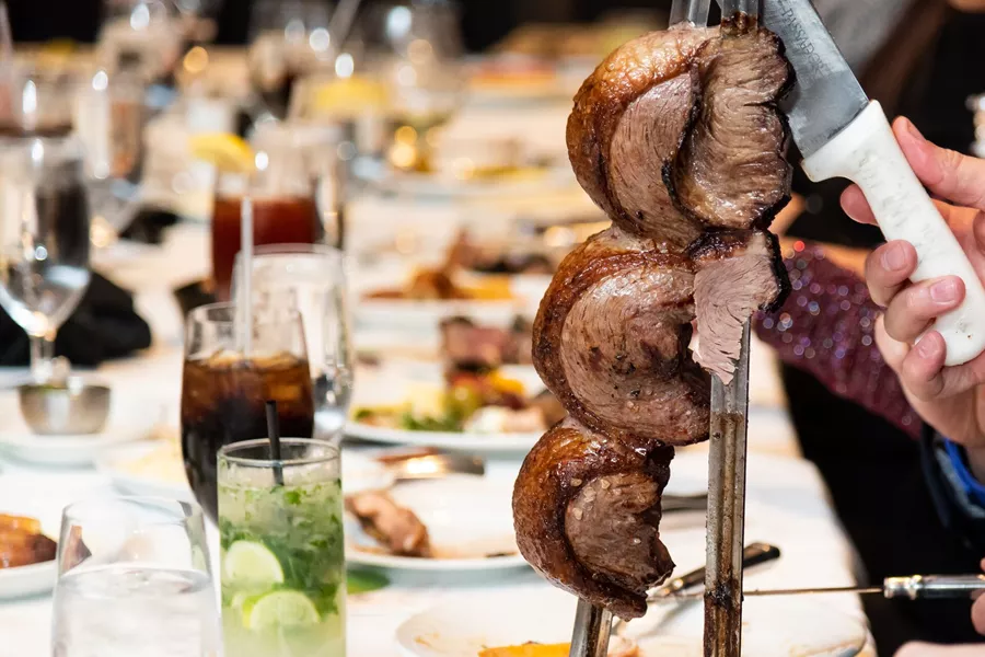 Steak on spit being sliced in a Brazilian Steak House