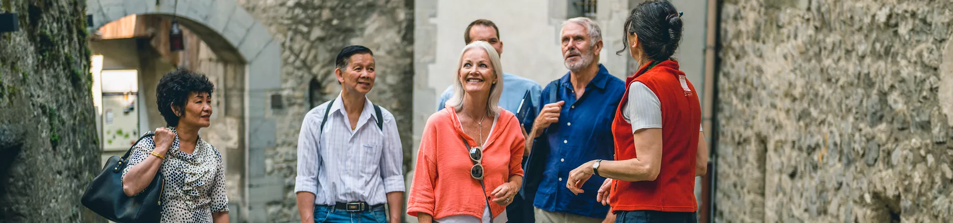 A group of people wandering down a medieval town.