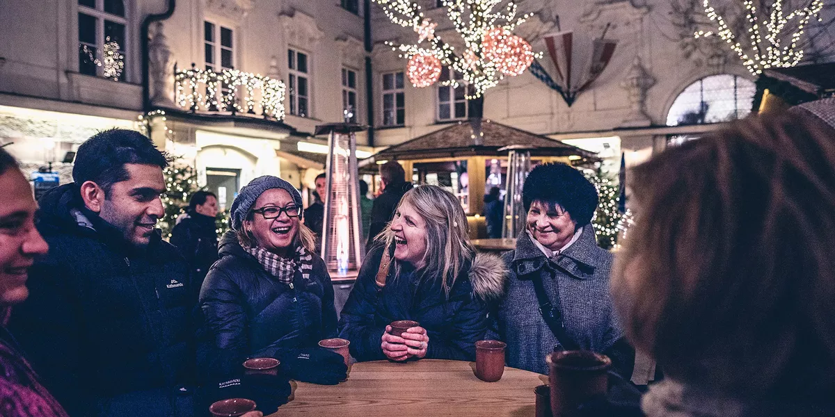 Group of people enjoying Gluhwein together at the Christmas Market in Salzburg, Austria