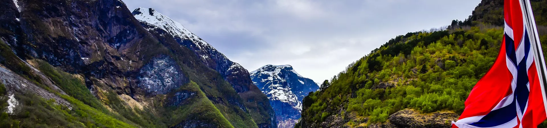 Cruise On The Nærøyfjorden in Norway with the Norwegian flag in the foreground