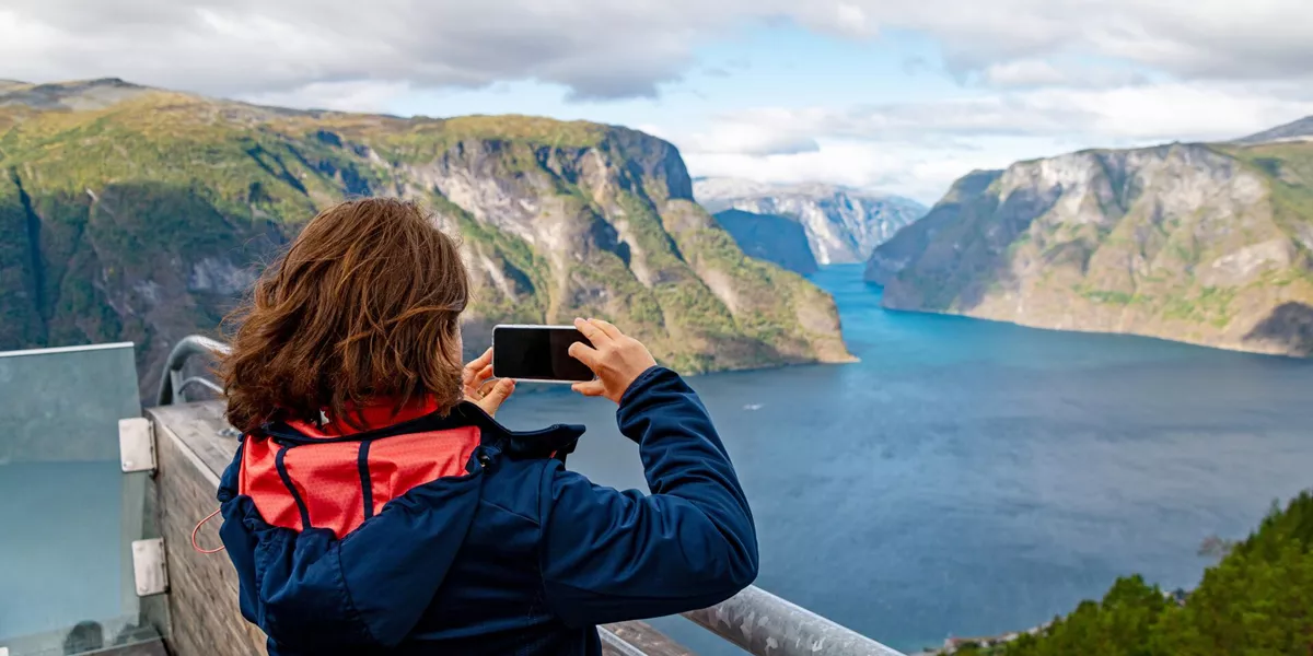 Woman looking at Aurlandsfjord from Stegastein viewpoint in Norway, Scandinavia