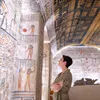 Woman examining hieroglyphics at Ramesses VI Tomb in Luxor, Egypt