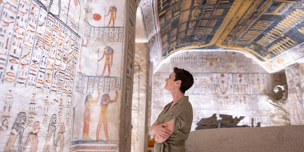 Woman examining hieroglyphics at Ramesses VI Tomb in Luxor, Egypt