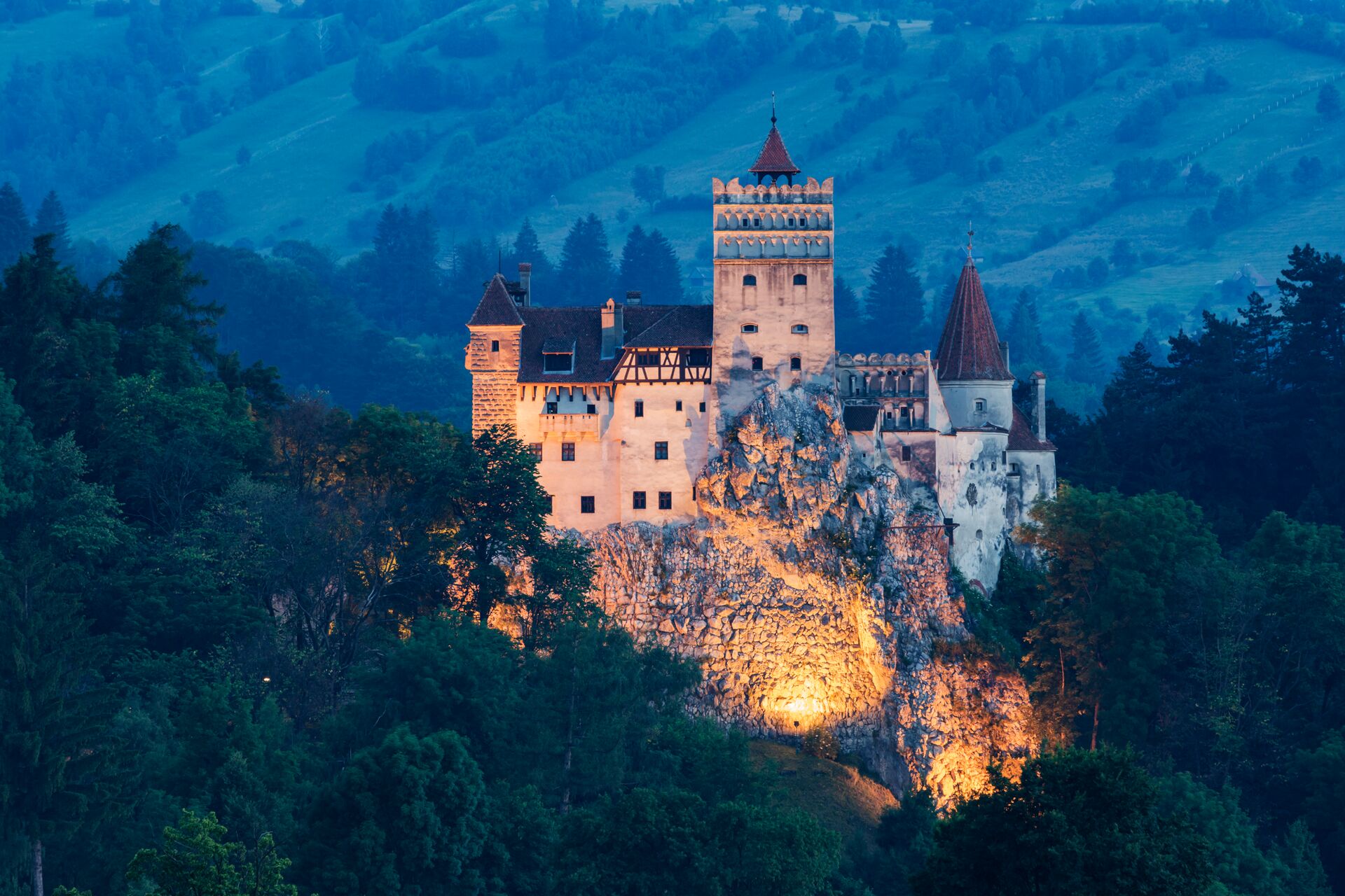 Illuminated Bran Castle on a hill in Bran, Transylvania, Romania