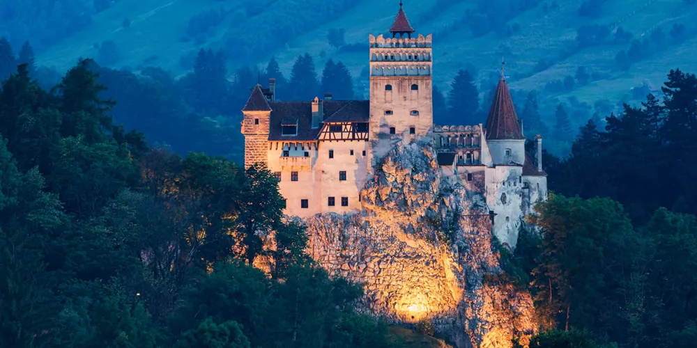 Illuminated Bran Castle on a hill in Bran, Transylvania, Romania