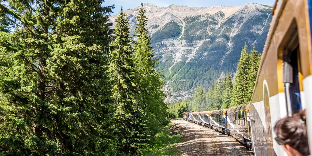Woman looking at the mountains while riding the Rocky Mountaineer Train in Vancouver, British Columbia Canada