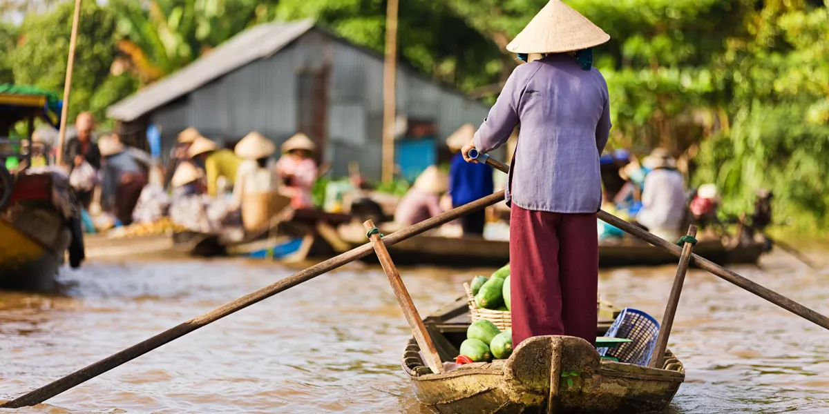 Vietnamese woman rowing a boat in the Mekong River Delta, Vietnam