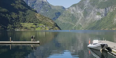 Group of people sitting overlooking Geirangerfjord Western Fjords Norway