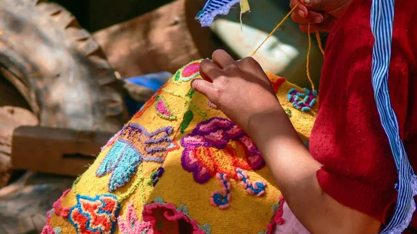 Colourful embroidery being made on a piece of fabric