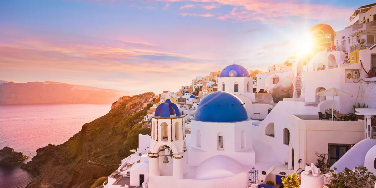 Sunset view of the blue dome churches of Santorini in Oia, Greece