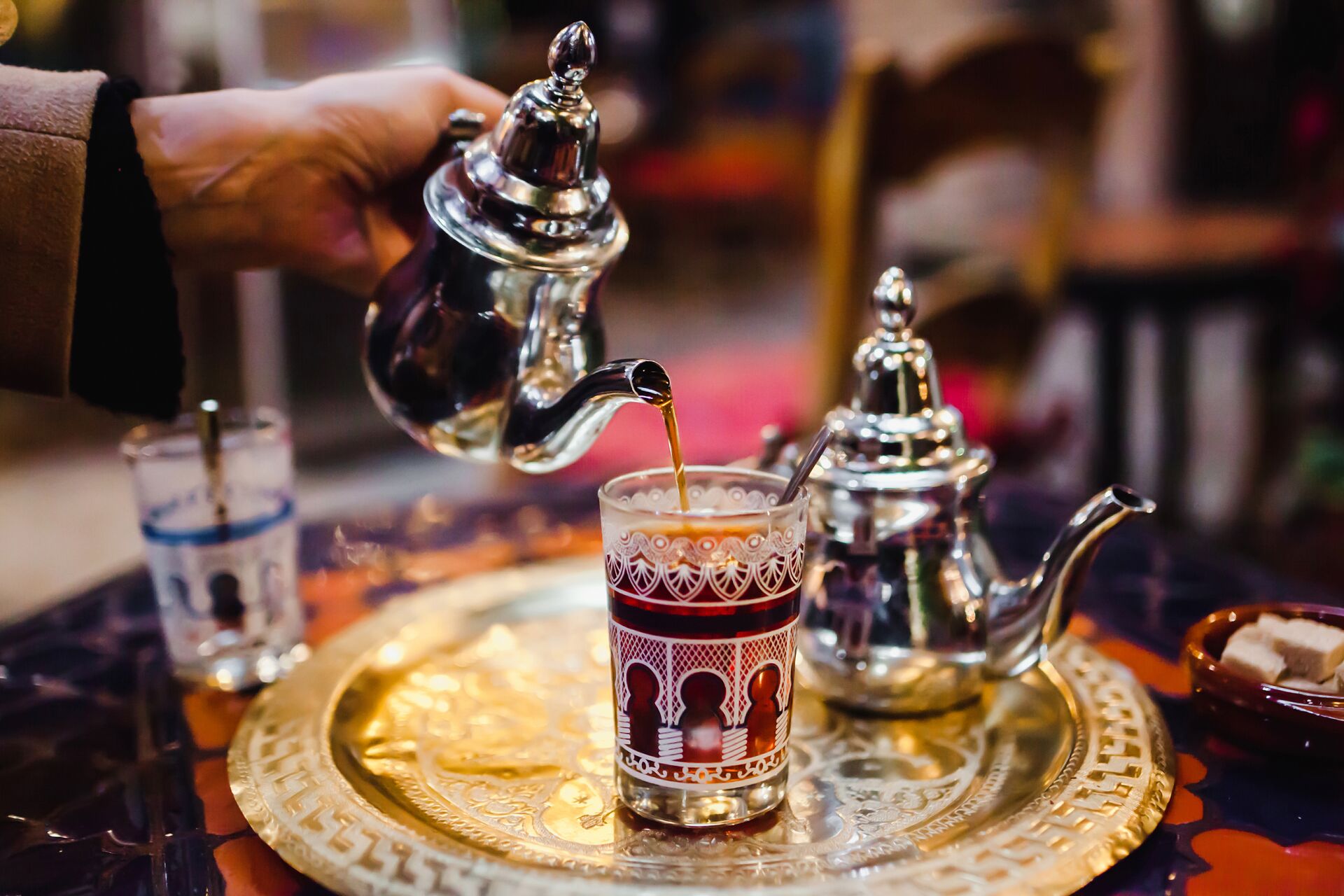 Tea being poured from a traditional Arabic tea set